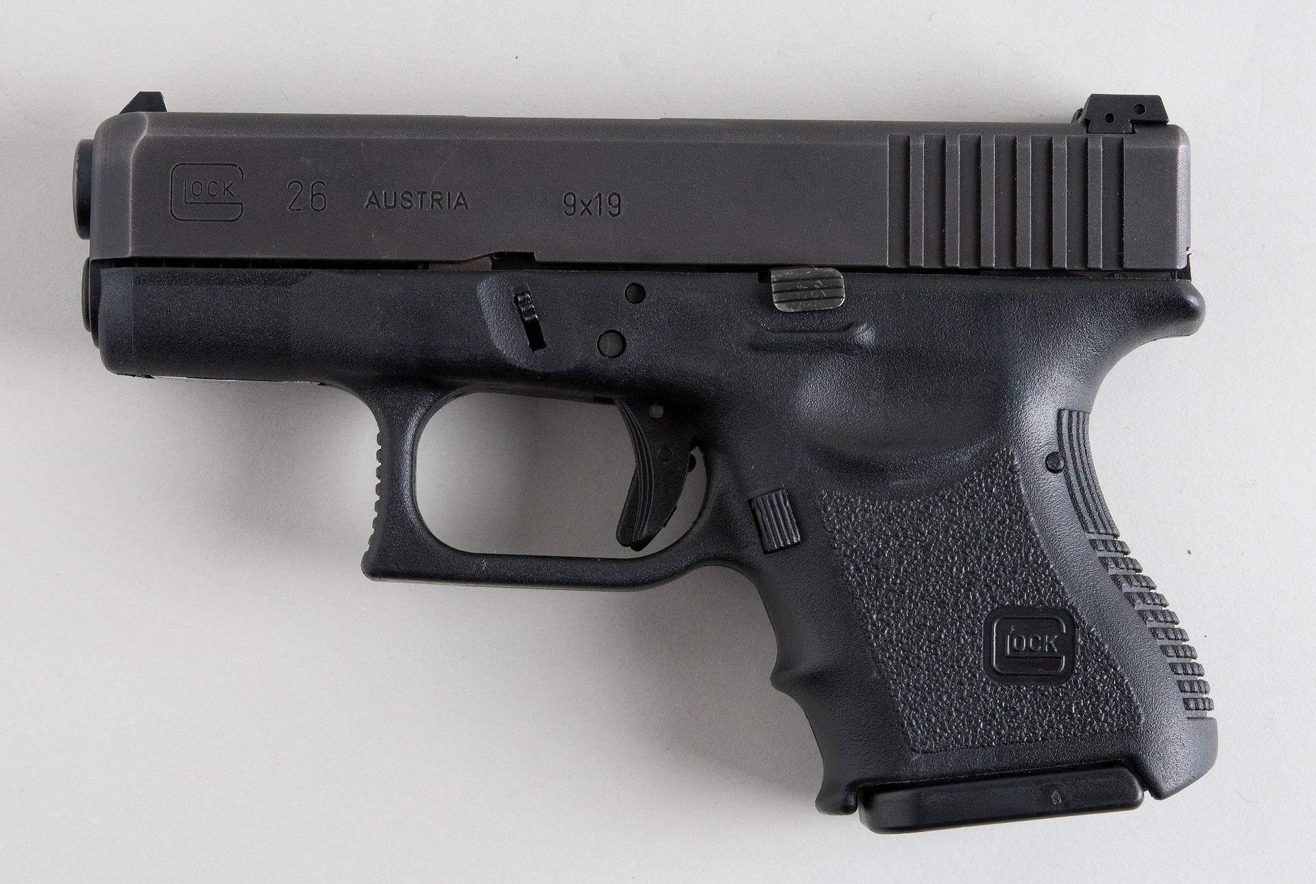 黑色 Glock 26 手槍在白色背景上，標記可見