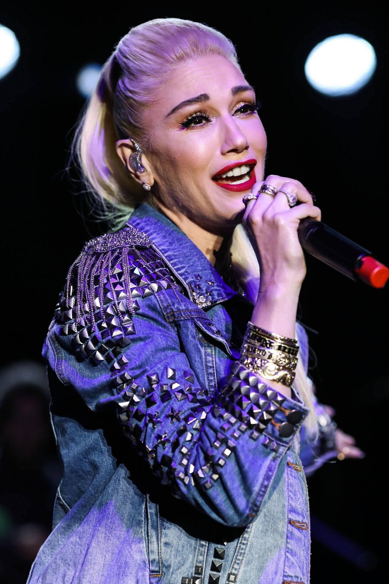 Gwen Stefani 穿著飾有鉚釘的牛仔外套在台上現場表演。