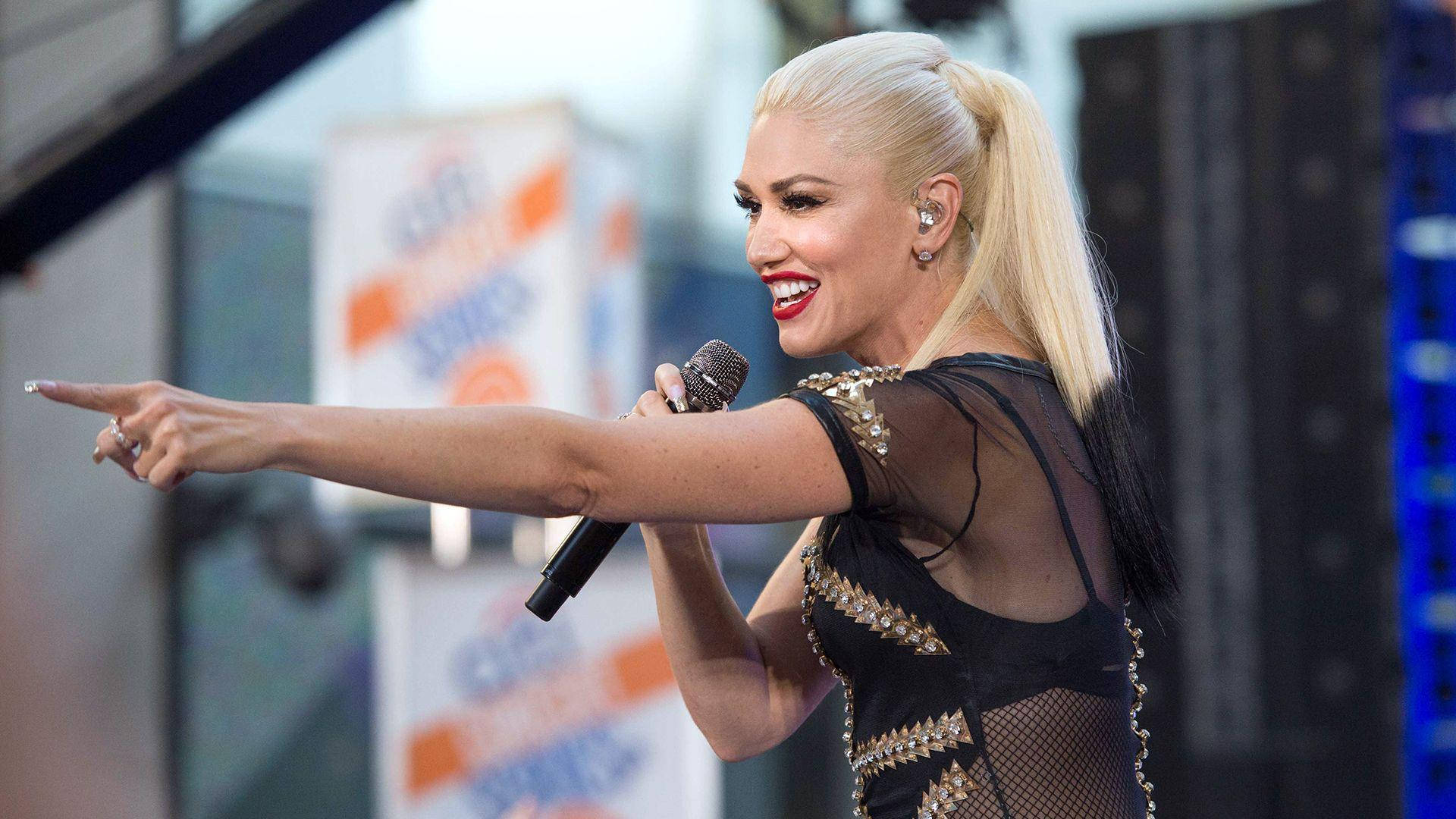 Gwen Stefani 在現場演唱會表演中唱歌並指向粉絲。