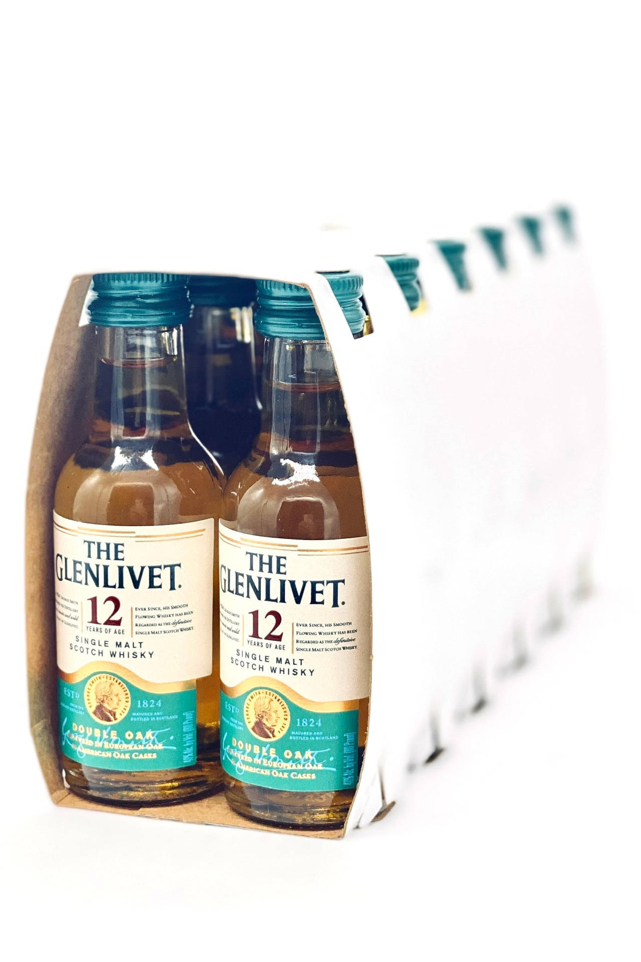 六個迷你 Glenlivet 威士忌酒瓶放在白色背景的紙板包裝中。
