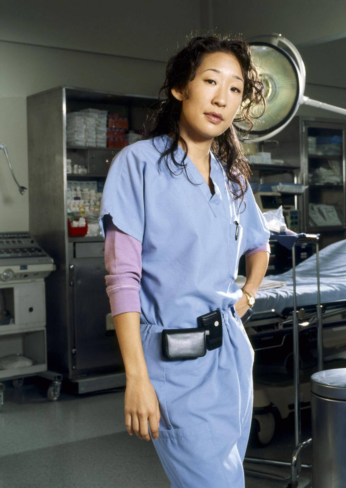 身穿藍色手術服的女外科醫生站在手術室中，配有醫療設備。