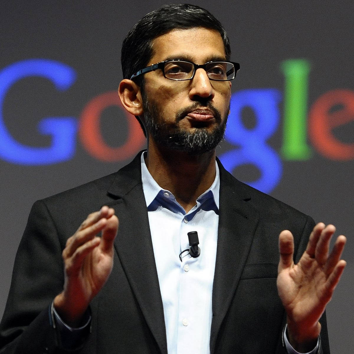 Sergey Brin 在Google活動中穿著西裝和眼鏡發言。