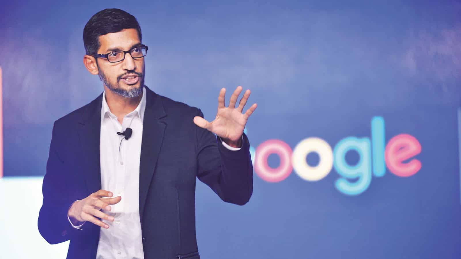 穿西裝的男子在Google活動中演講，身後有彩色標誌。