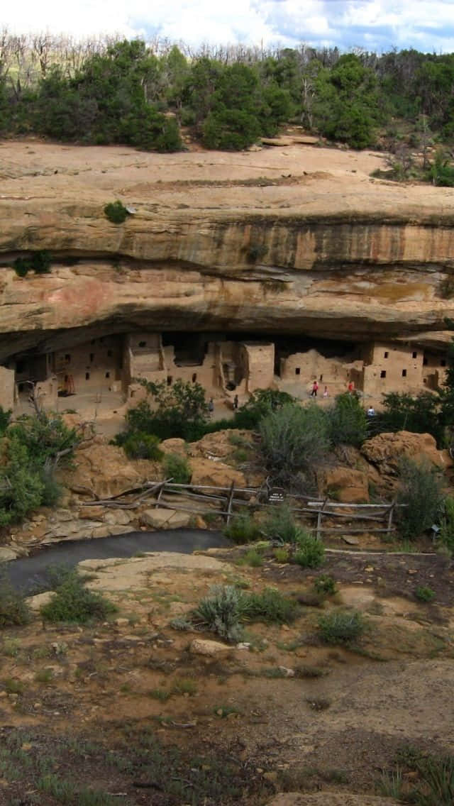 古代懸崖住宅，遊客探索歷史遺址。