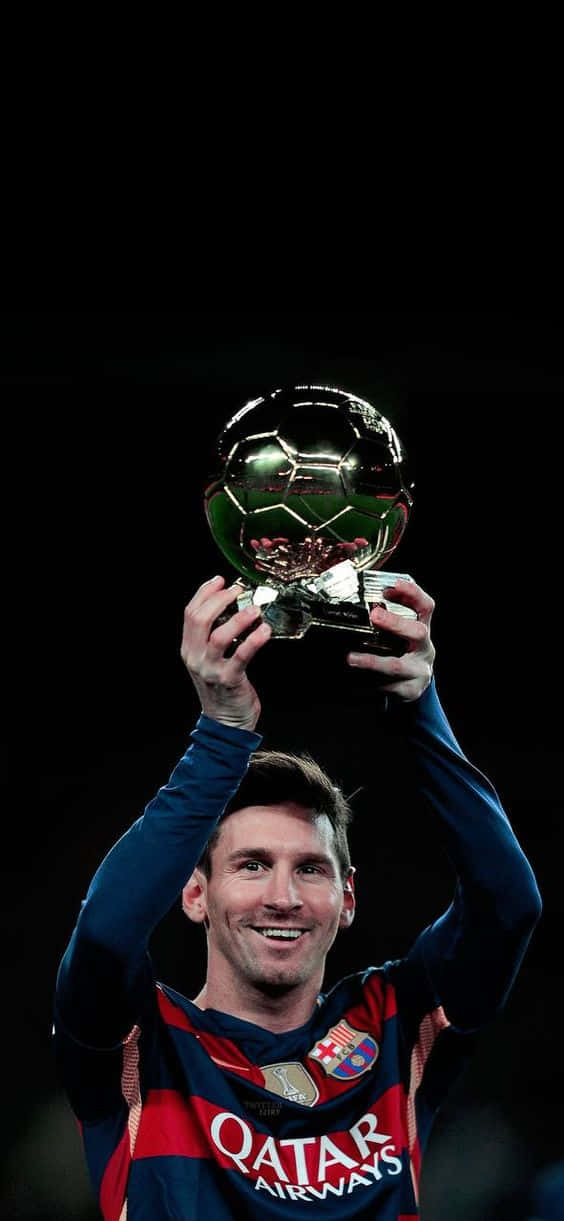美斯微笑著高舉金色足球獎盃。