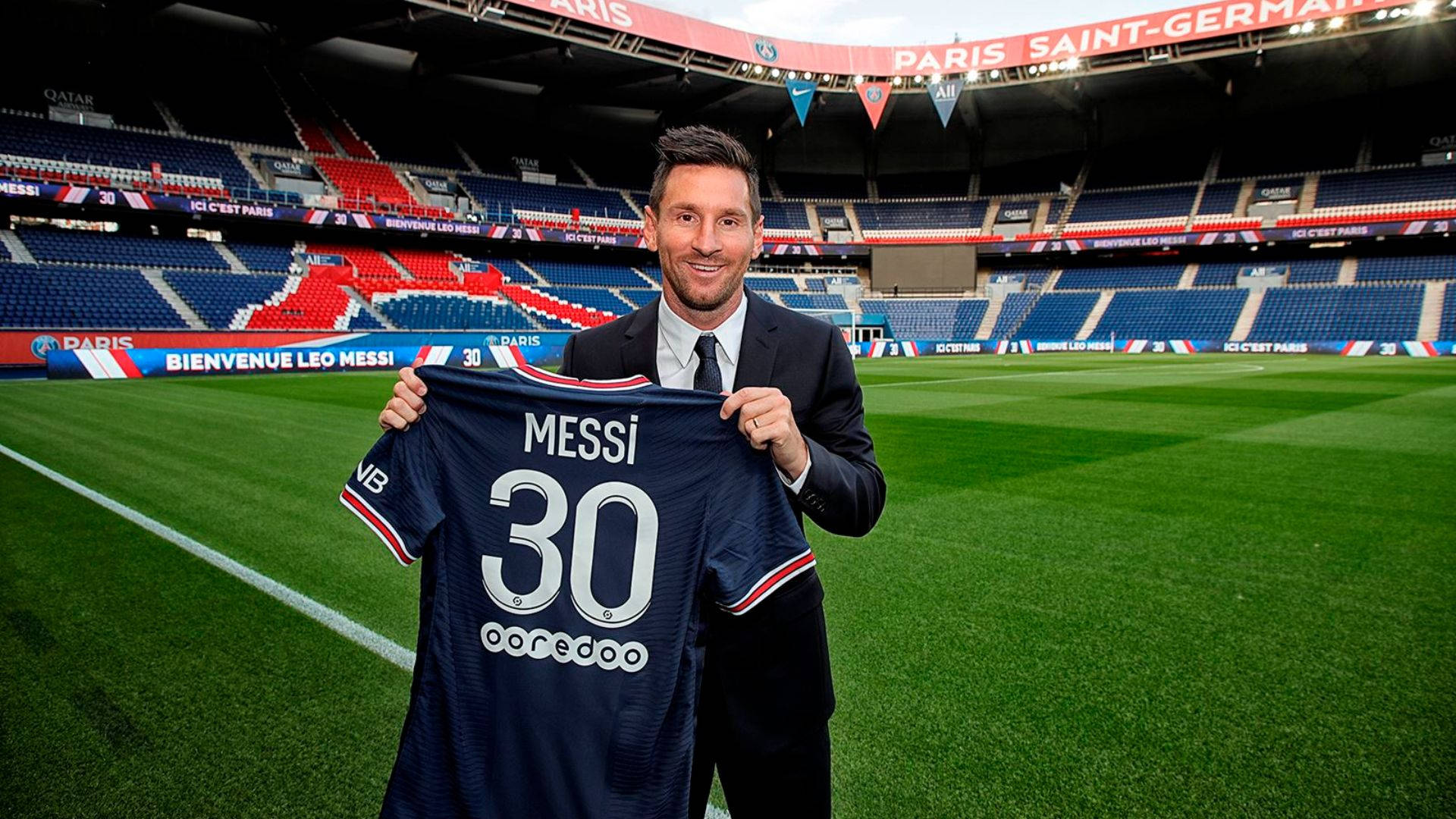 里奧·美斯在球場上手持他的PSG 30號球衣。