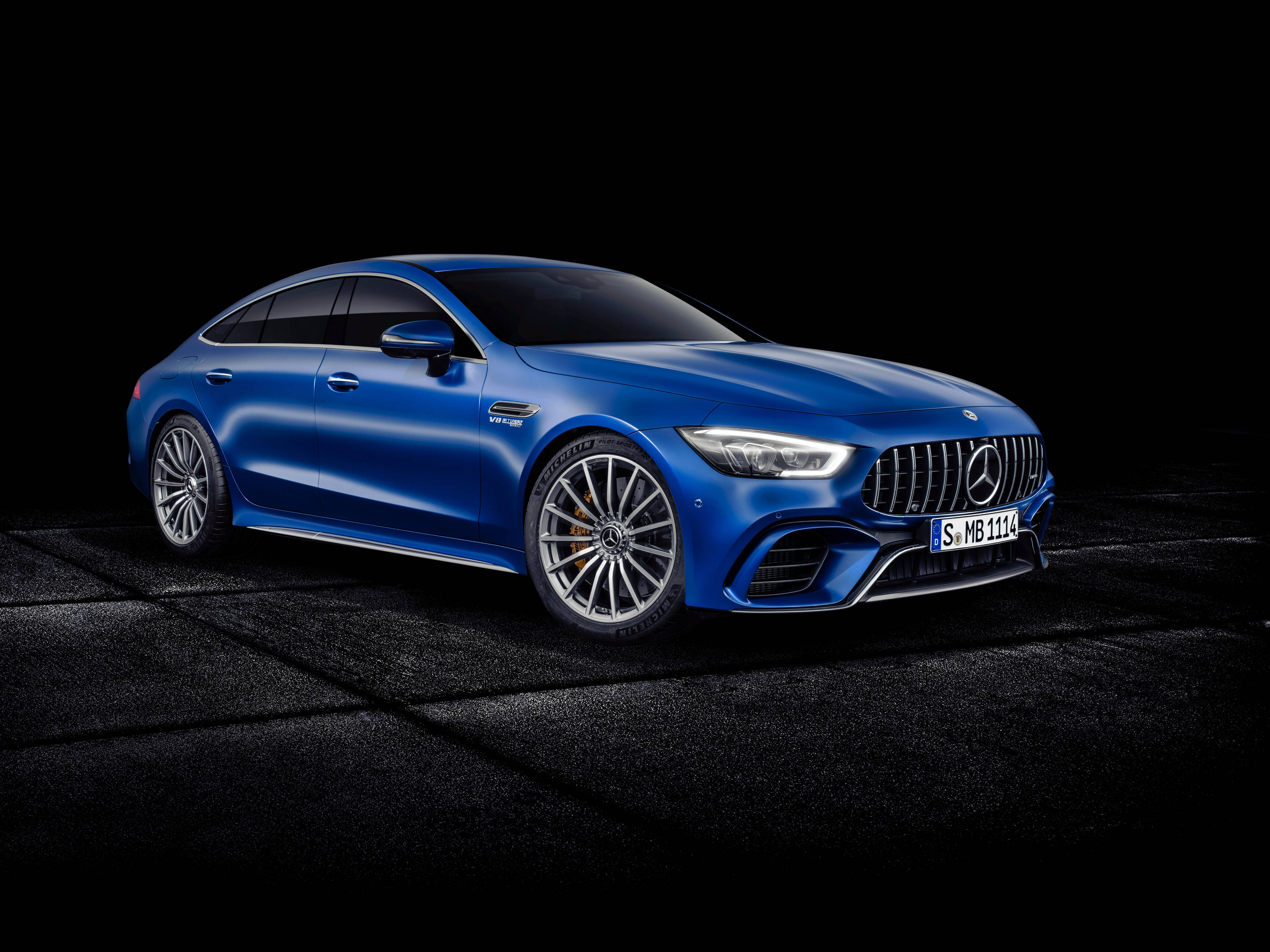 梅賽德斯-AMG 超跑 壁紙 — 一輛時尚的藍色Mercedes-AMG GT 63 S E Performance轎跑車在黑色背景的攝影棚燈光下閃耀。