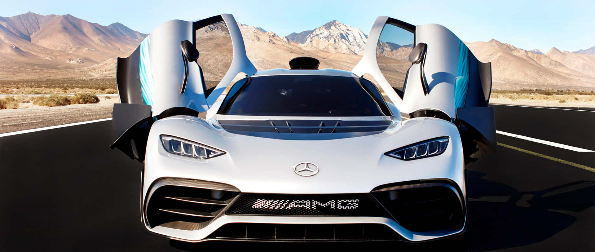 白色Mercedes-AMG One超級跑車，鷗翼車門打開，停在沙漠公路上，靠近山脈，夕陽時分。
