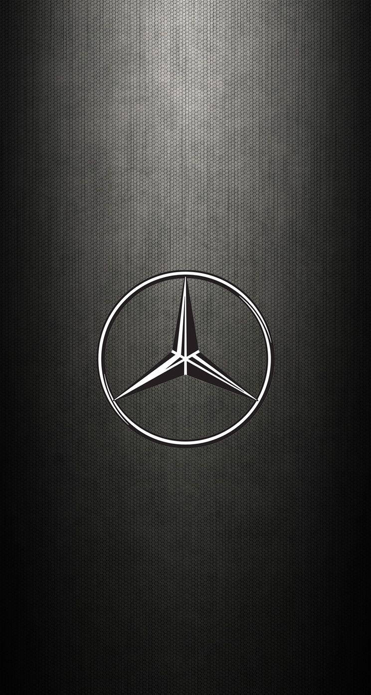 Mercedes-Benz 標誌在深色紋理背景上帶有光線。