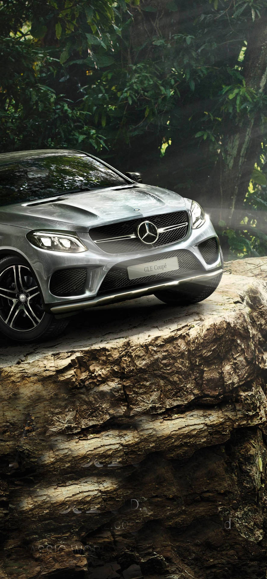 銀色 Mercedes-AMG GLE Coupe 停泊在森林中的岩石露頭上。