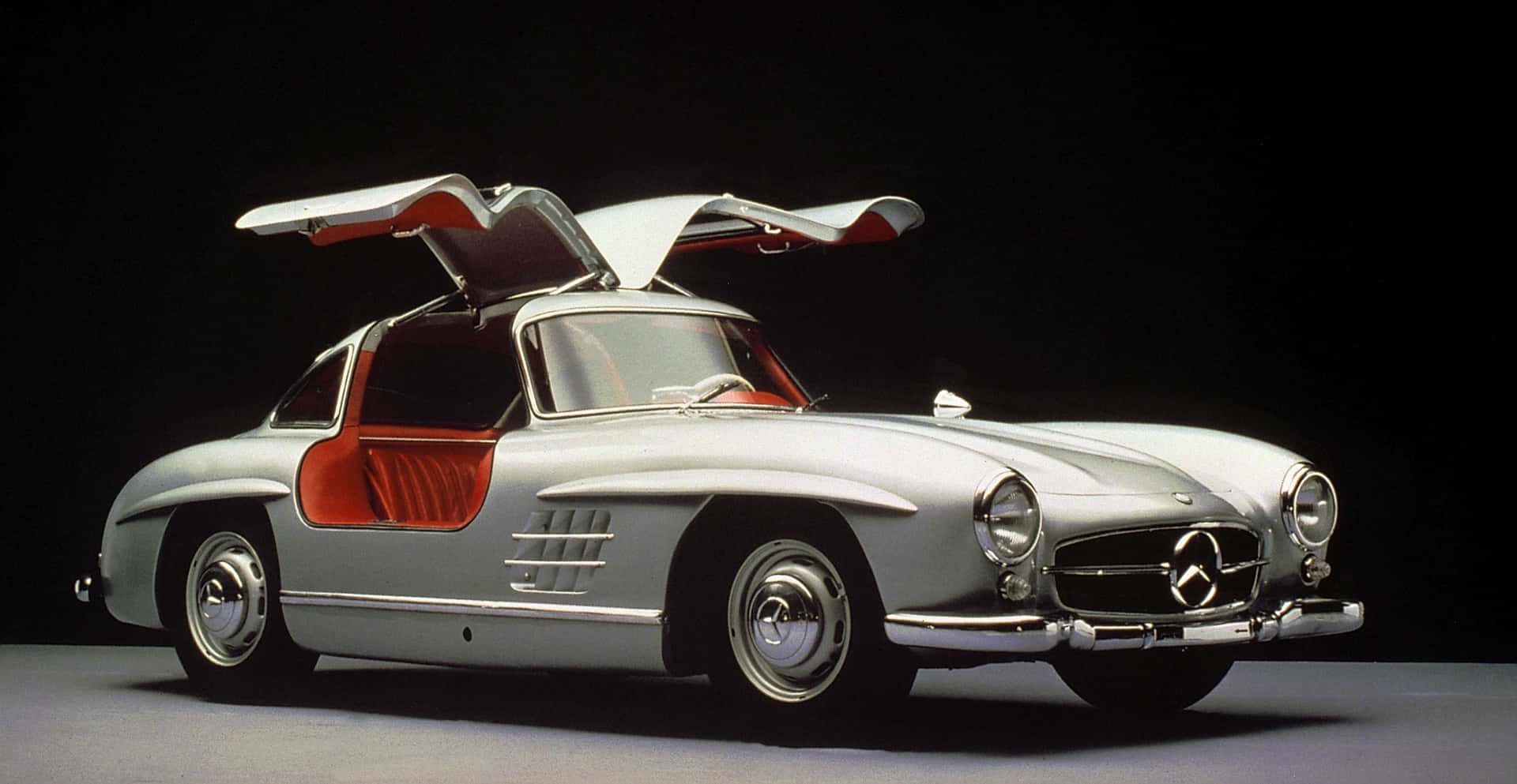 銀色平治300 SL，鷗翼車門打開，在攝影棚內。