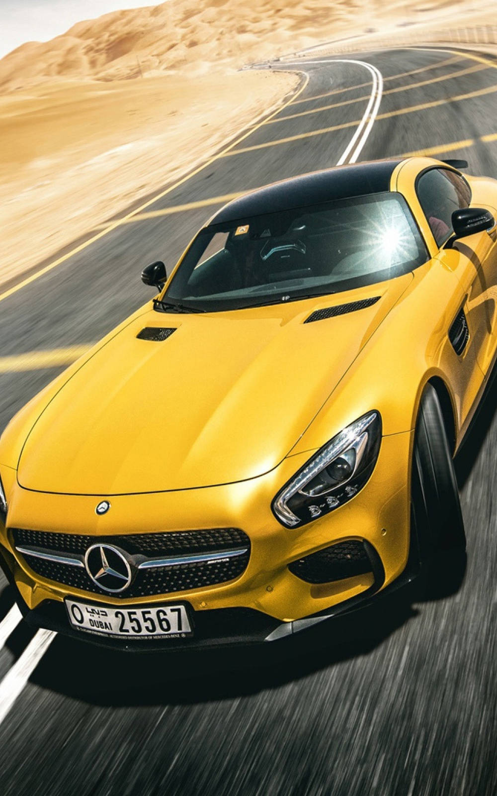 黃色 Mercedes 跑車在日落時分的沙漠公路上疾馳。