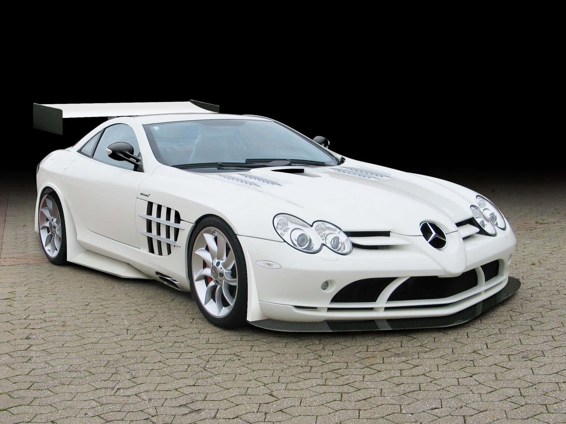 白色 Mercedes-Benz SLR McLaren 跑車在黑色背景的鵝卵石上。 — 白色 壁紙