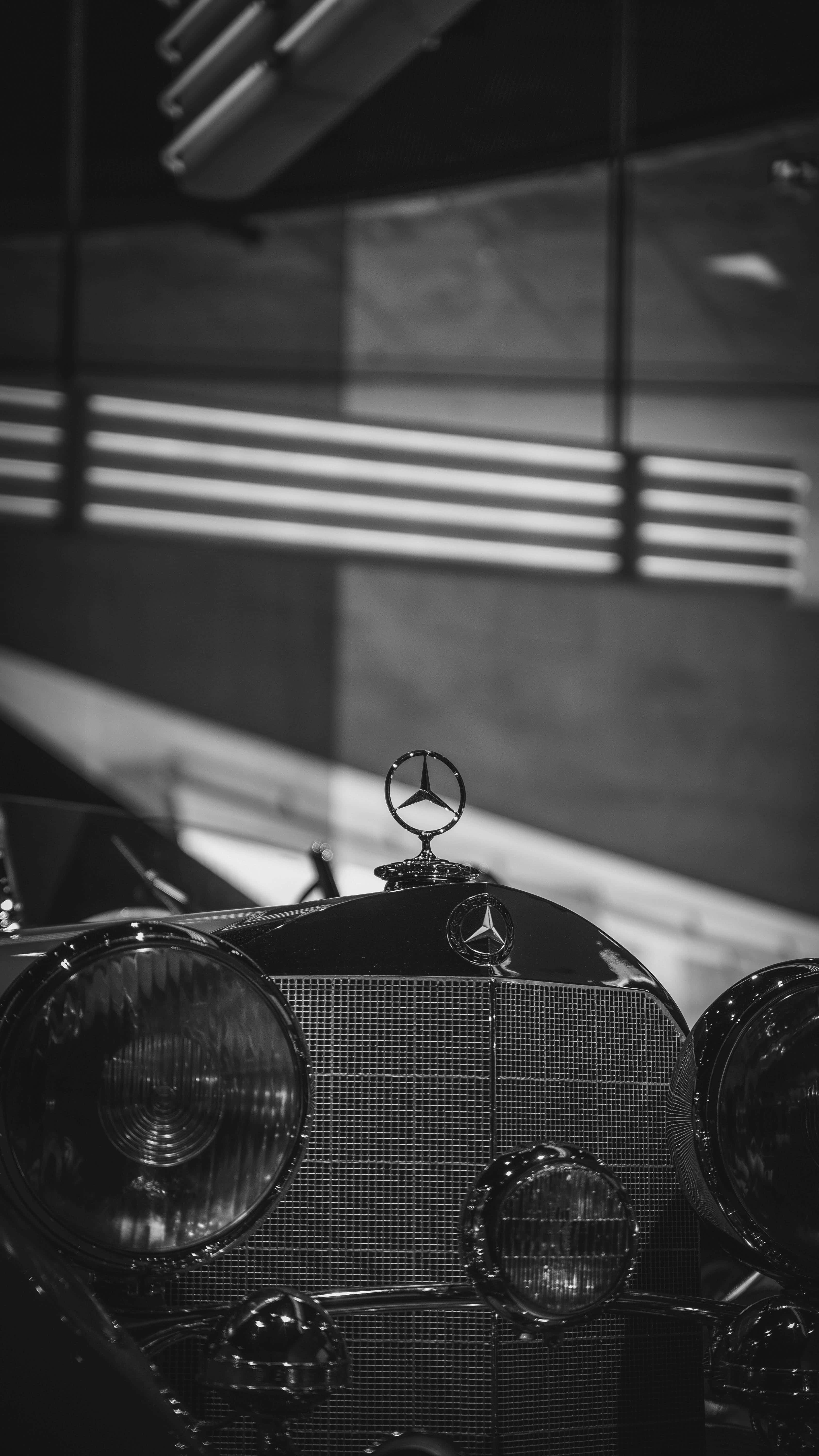 Black And White Vintage Car 桌布 壁紙 — 條紋燈光下經典平治鬼面罩及星形標誌的黑白特寫。