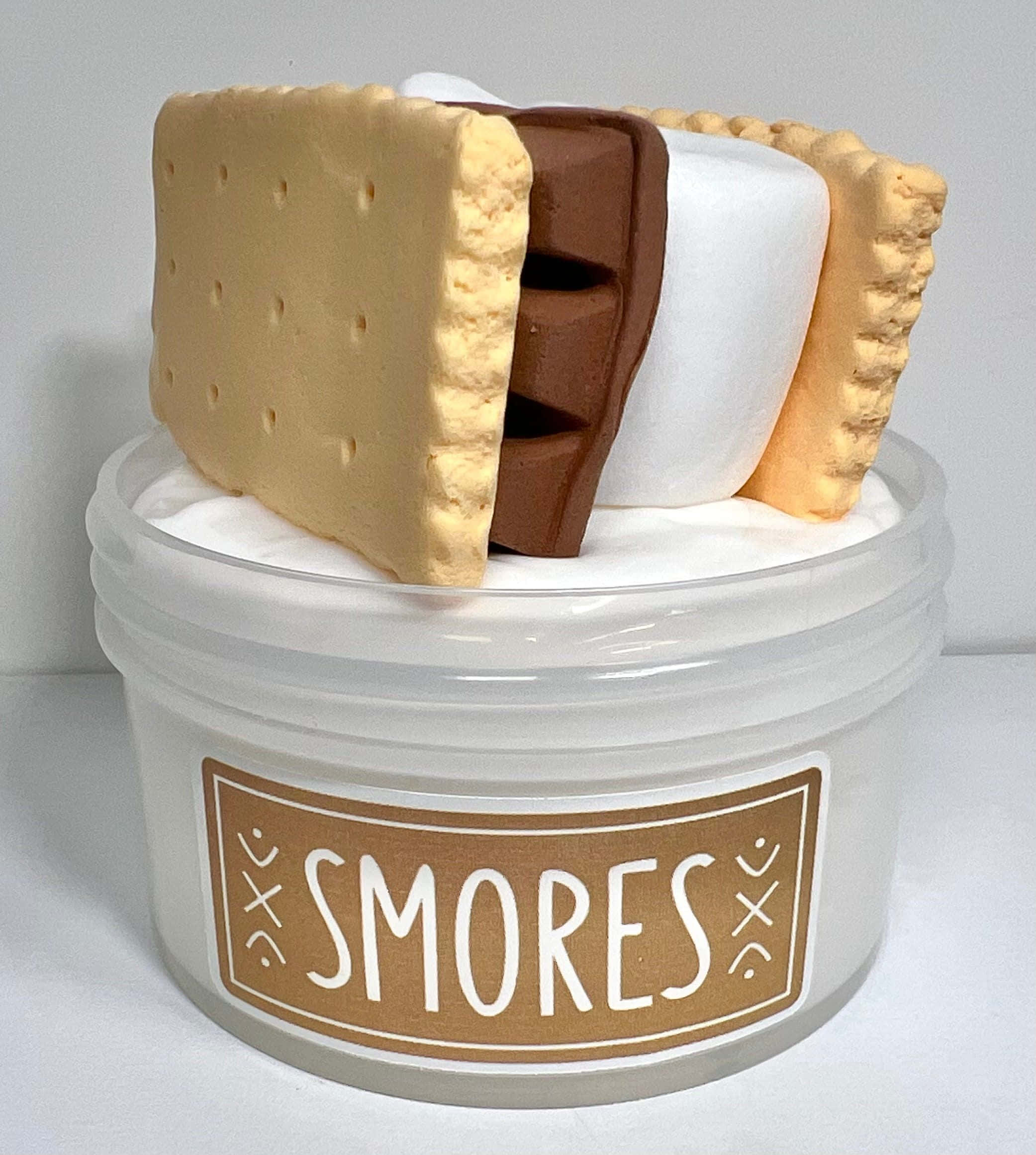 棉花糖史萊姆圖像 壁紙 — 一個逼真的 s'mores 甜品複製品，包含全麥餅乾、朱古力和棉花糖，放在一個有標籤的罐子上，背景為純白色。