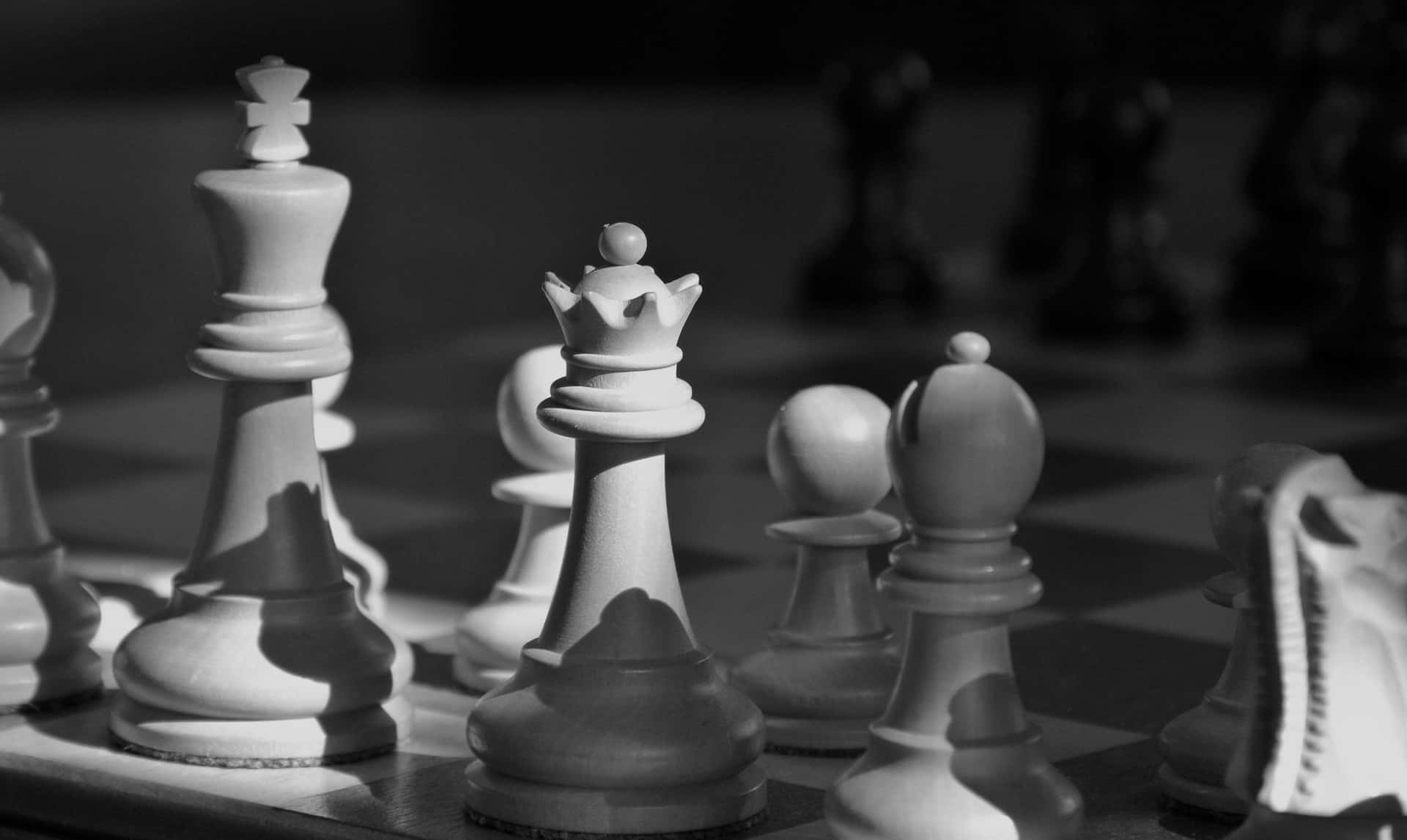 Black And White Chess 桌布 壁紙 — 棋盤上棋子的單色特寫，具有戲劇性燈光和淺景深效果。