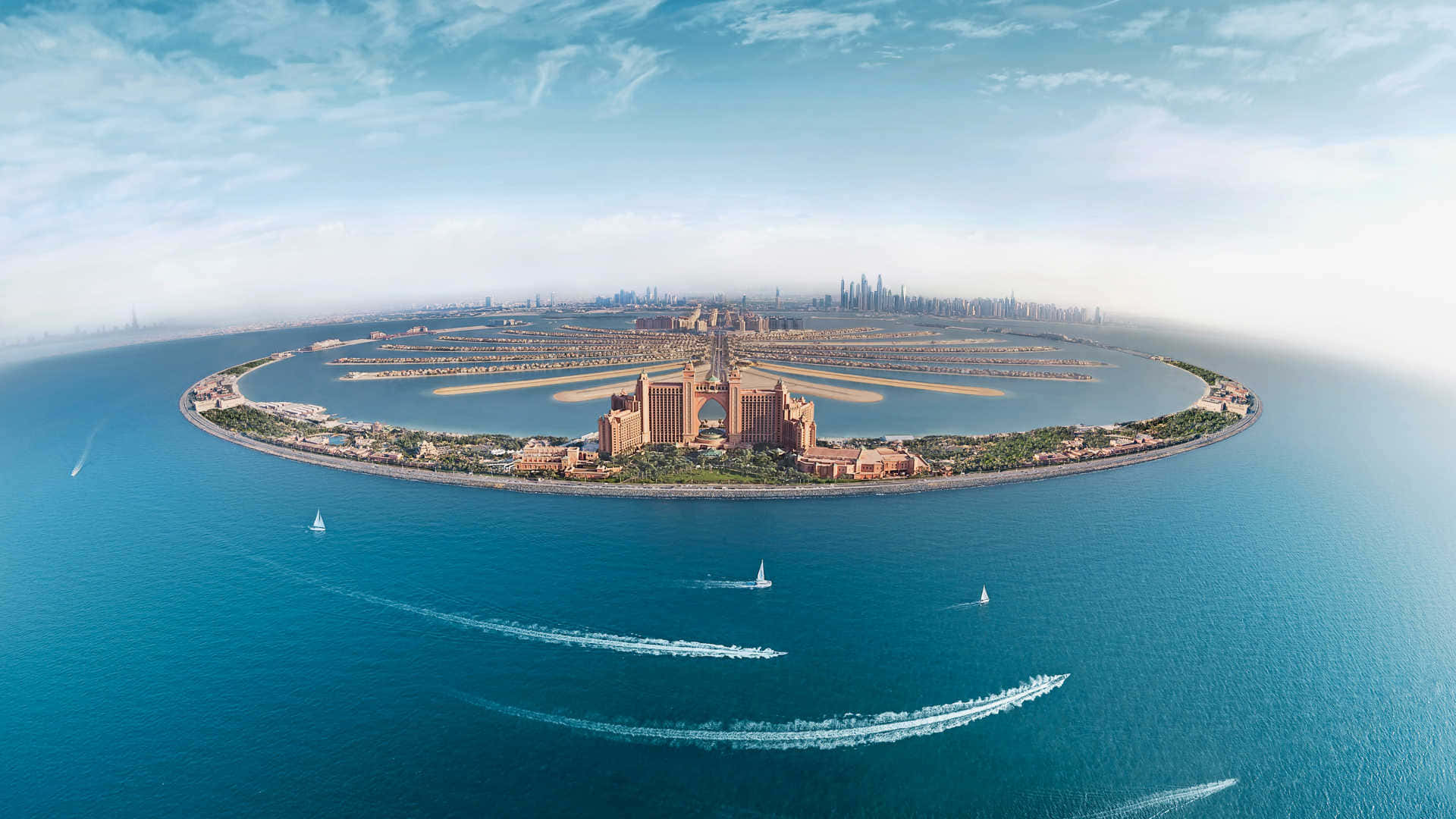 Dubai 桌布 壁紙 — 棕櫚島的鳥瞰圖，豪華酒店和帆船在湛藍天空下的碧綠海水中滑行。