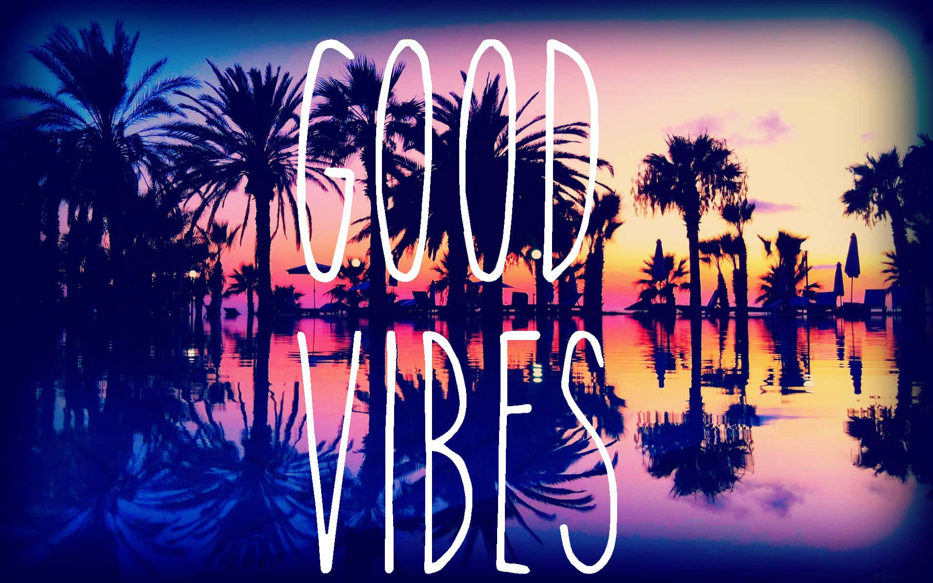 日落時分的棕櫚樹倒映在水中，帶有「GOOD VIBES」文字。