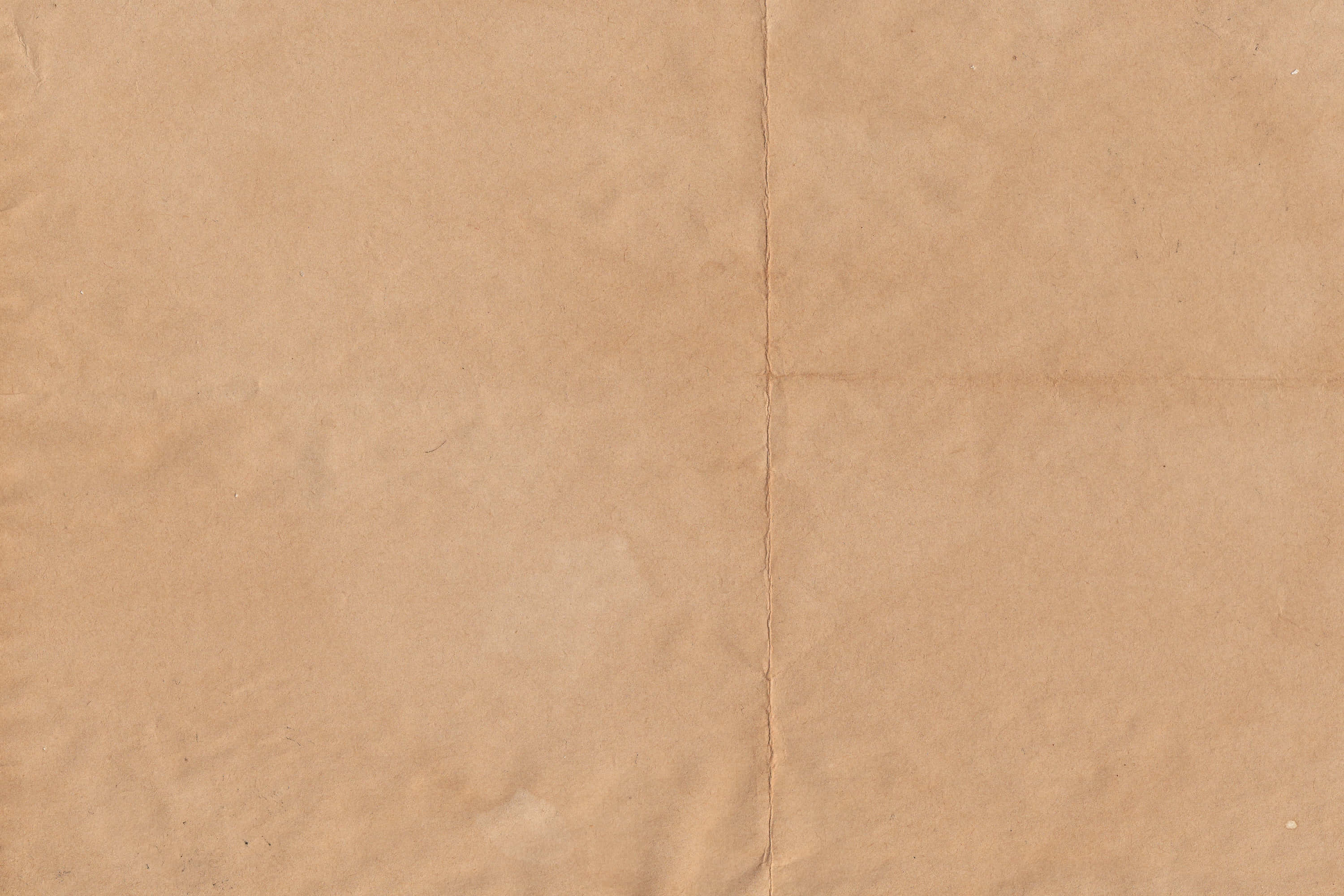 Brown Paper 桌布 壁紙 — 棕色紋理紙張的特寫，帶有可見的摺痕和細微污漬，營造出質樸的有機表面。