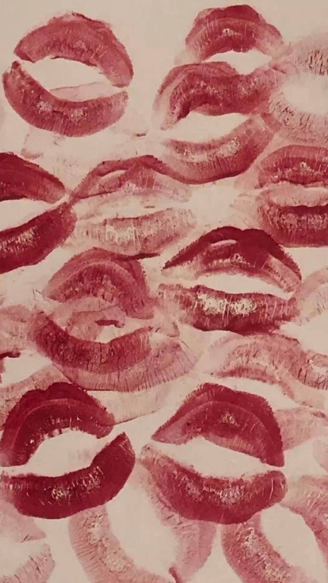 棕色紙上紅色吻印的俏皮少女圖像 壁紙 — 淡色背景上重疊的紅色唇膏吻痕紋理圖案。