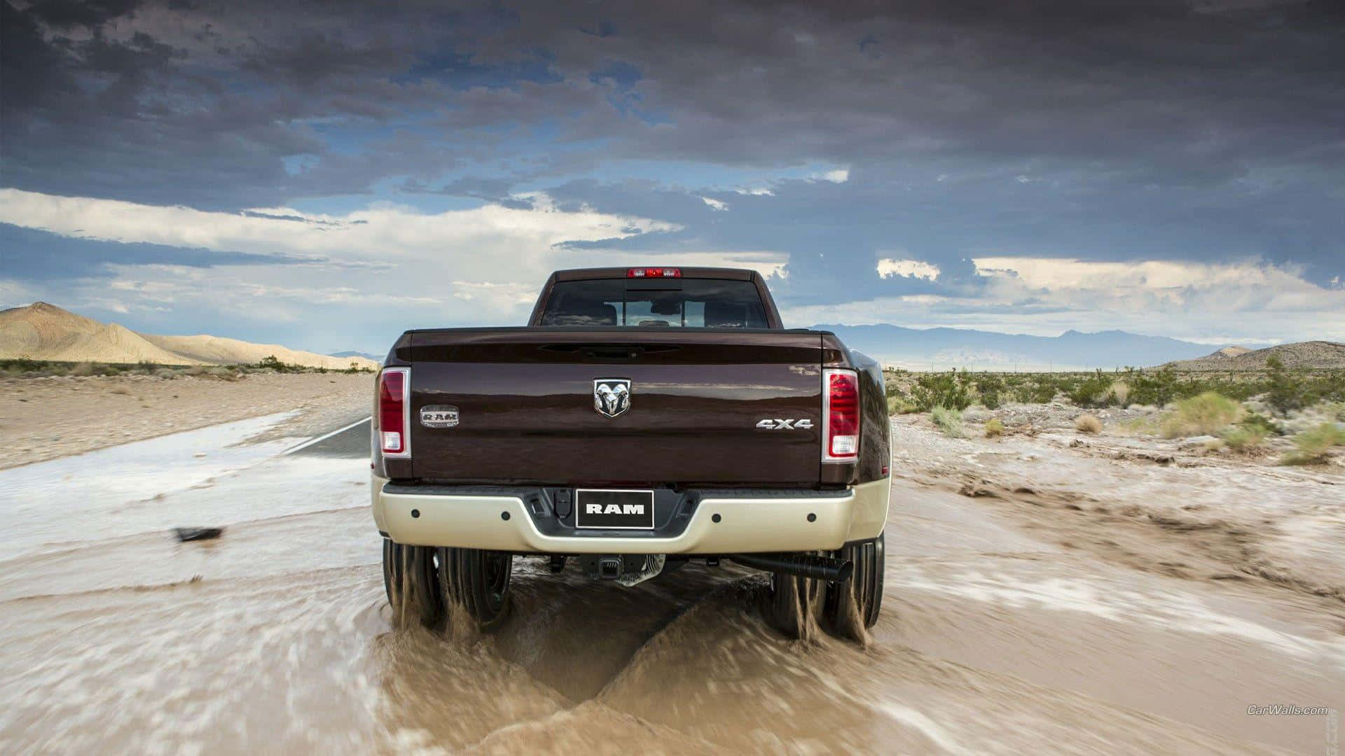 棕色Ram 4x4卡車在多雲天空下行駛穿過泥濘的沙漠地形。
