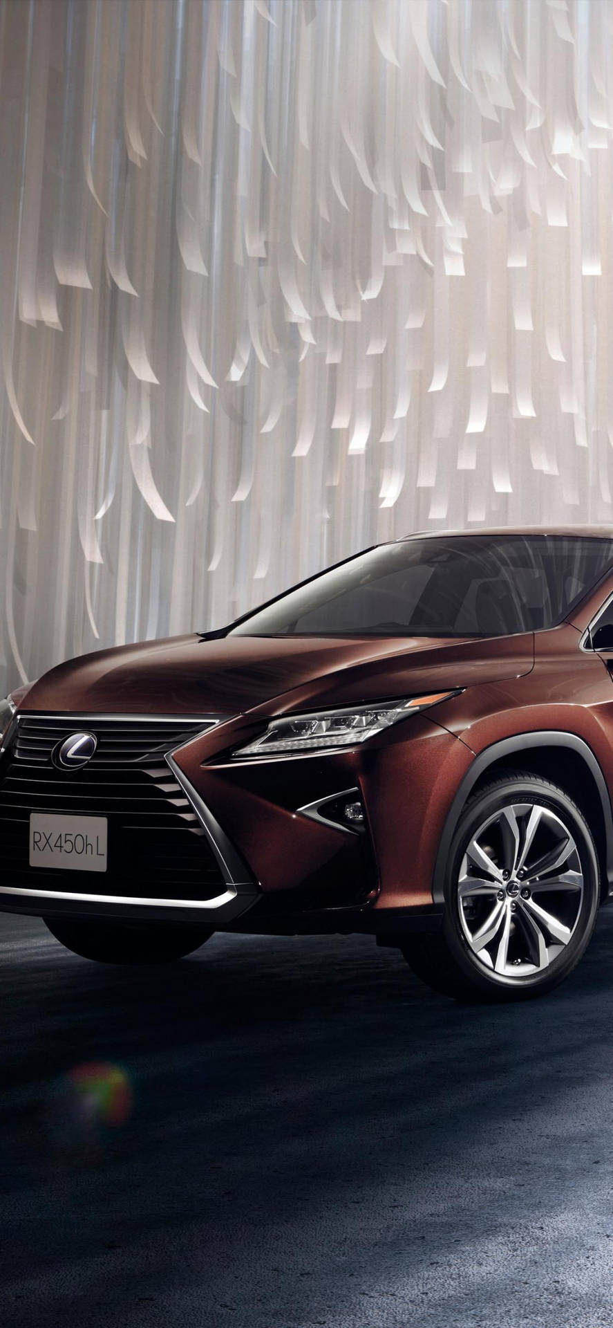 一輛青銅色Lexus RX450h L SUV在工作室中展示，配有白色布料窗簾。