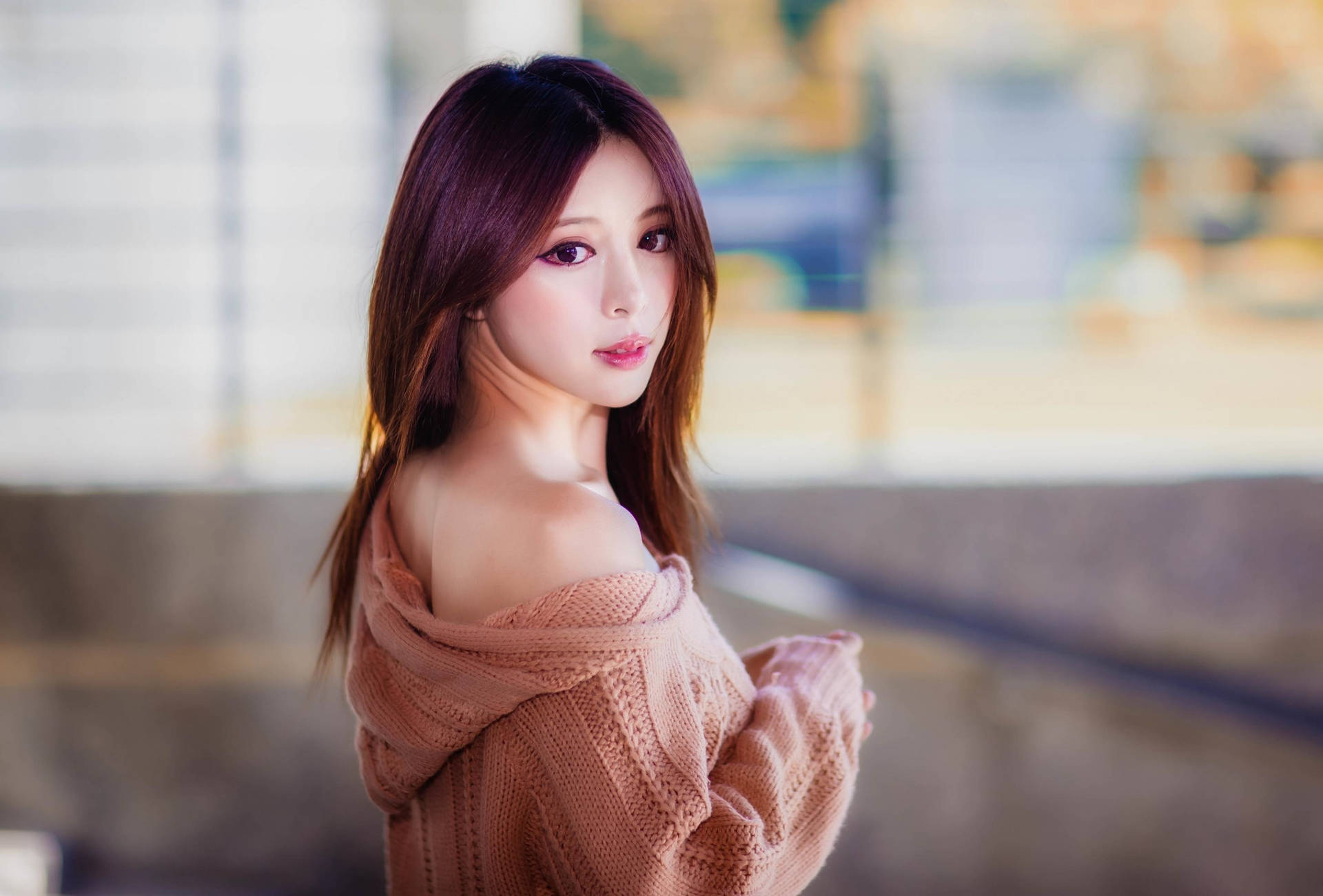年輕女性穿著粉紅色毛衣喺戶外望過膊頭