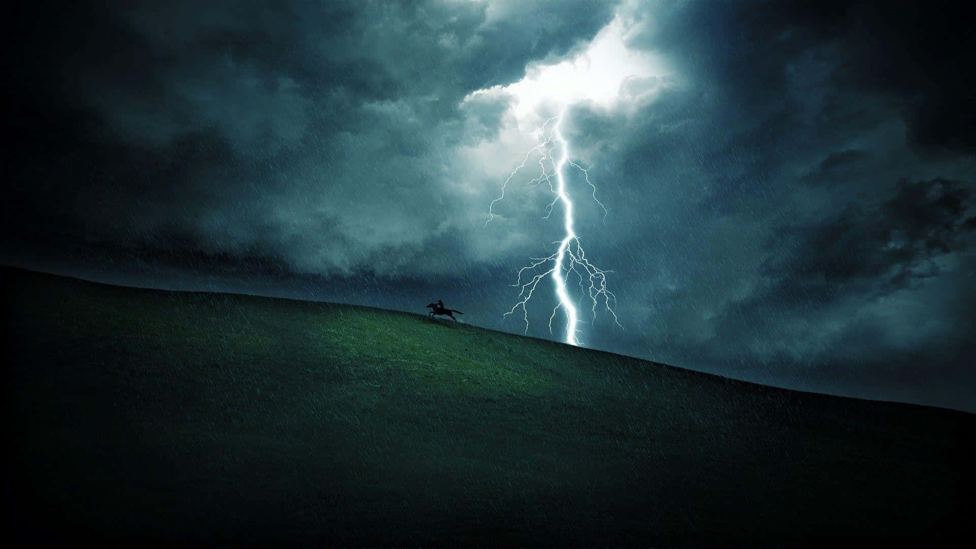 森林中的暴風雨之夜 壁紙 — 一個孤獨的騎手騎著馬，在戲劇性的山丘背景下形成剪影，一道巨大的閃電劃破暴風雨的天空。