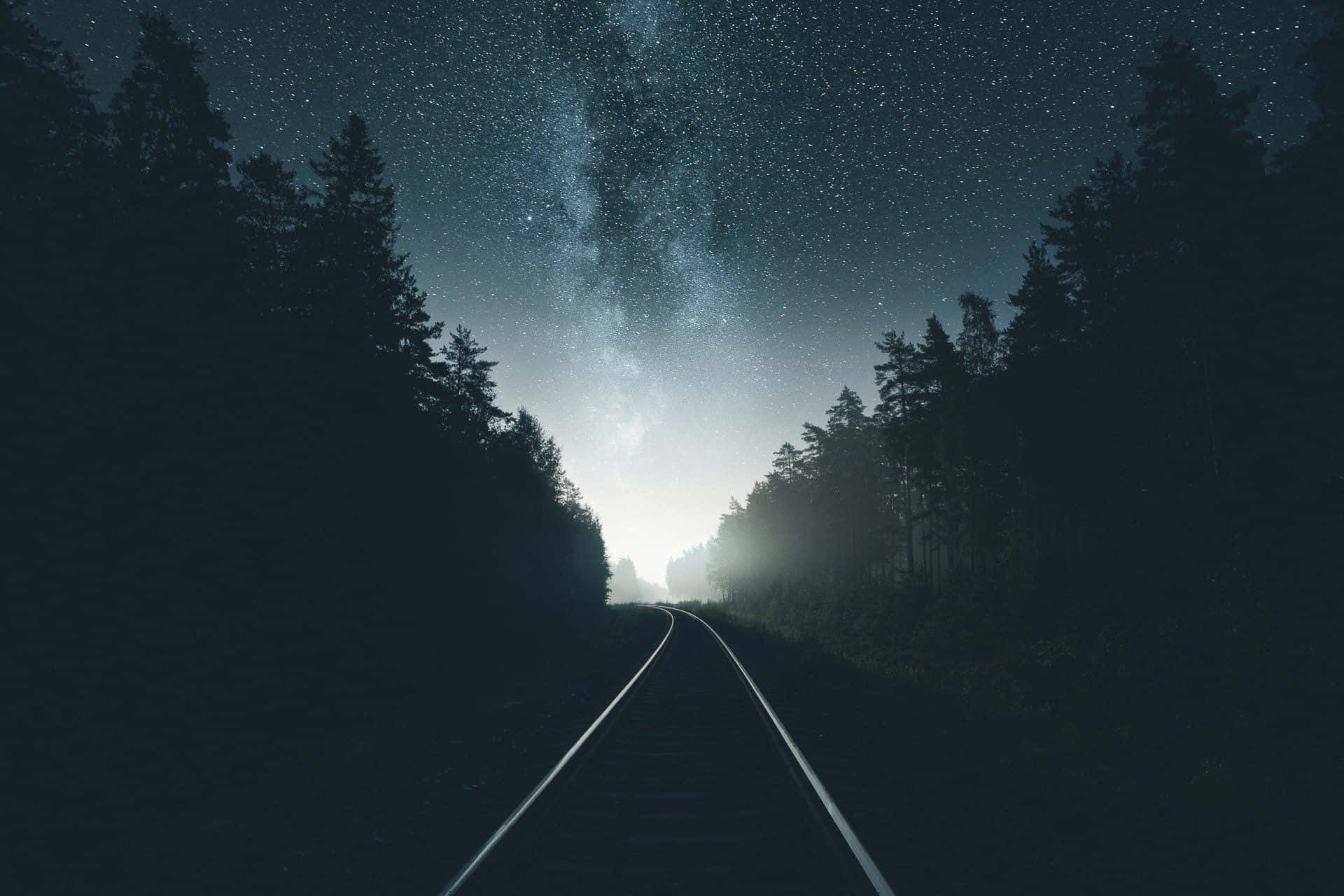 森林中的火車軌道與星空 壁紙