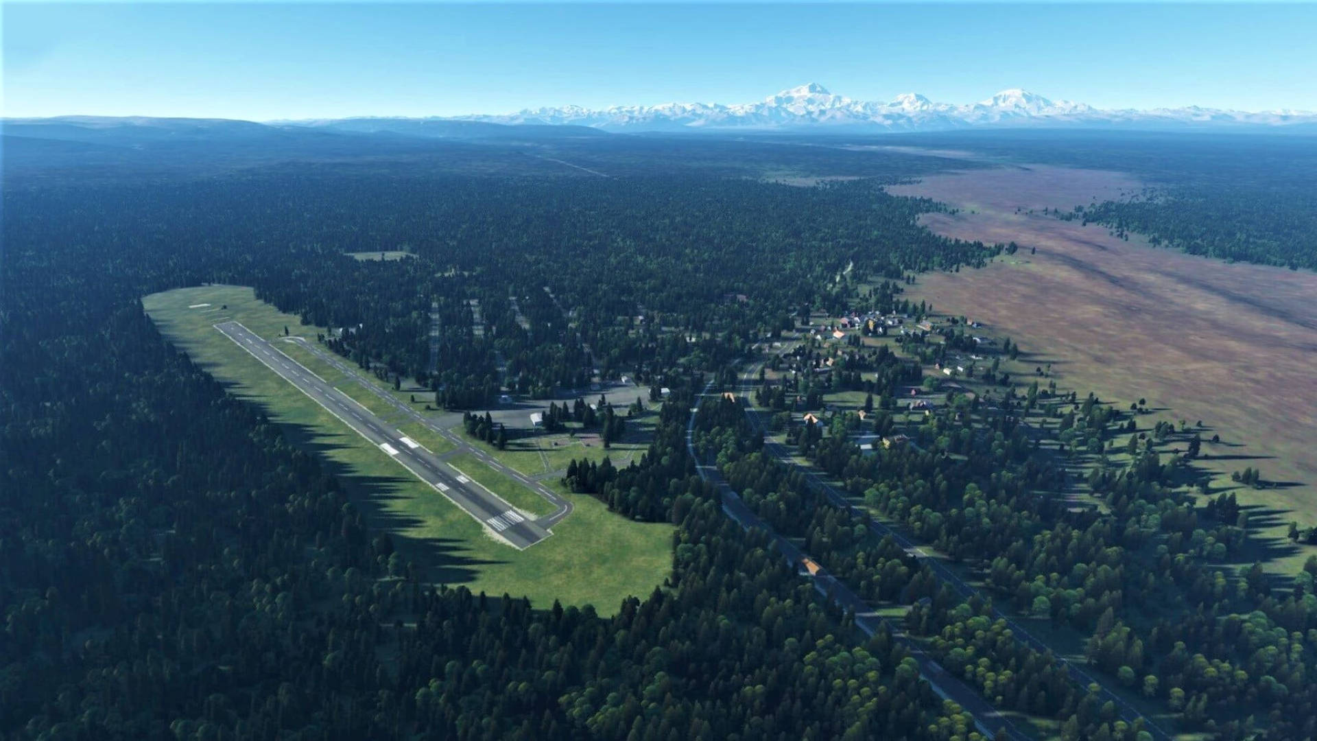 一個被森林環繞、背景有山的小型機場。