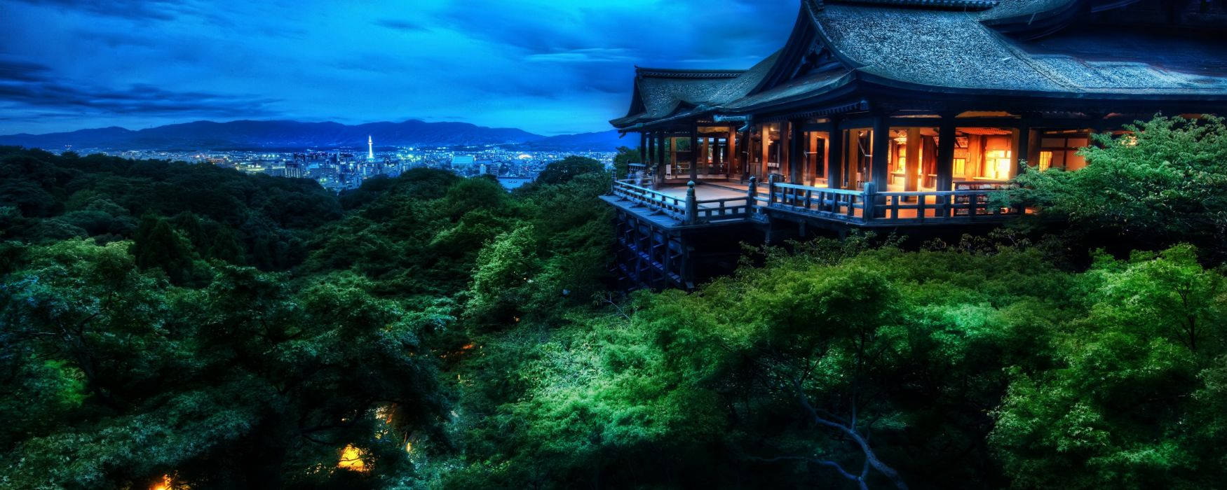 山丘上的寺廟，俯瞰夜晚的城市，窗戶閃爍，綠樹成蔭