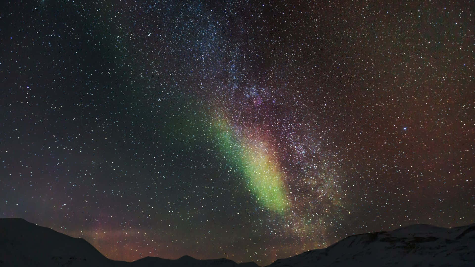 在繁星點點的夜空下，積雪的山峰上生動的極光