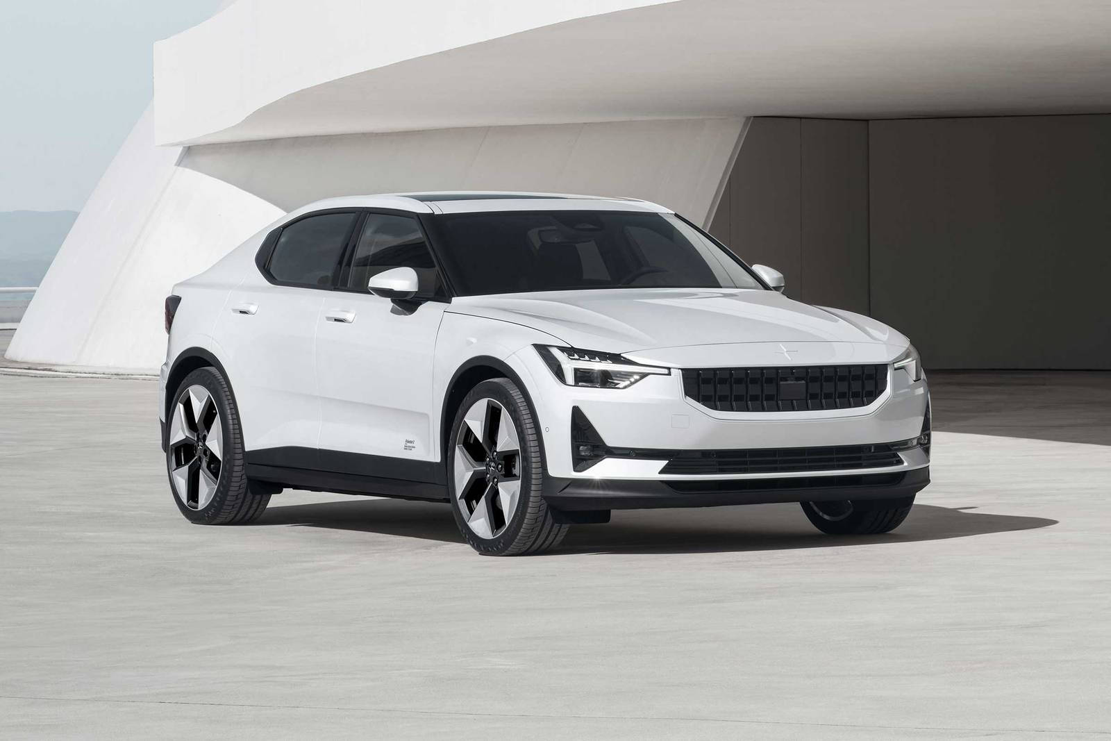 極星中型車 壁紙 — 一輛時尚的白色電動車在晴朗的日子停放在現代彎曲混凝土結構下。
