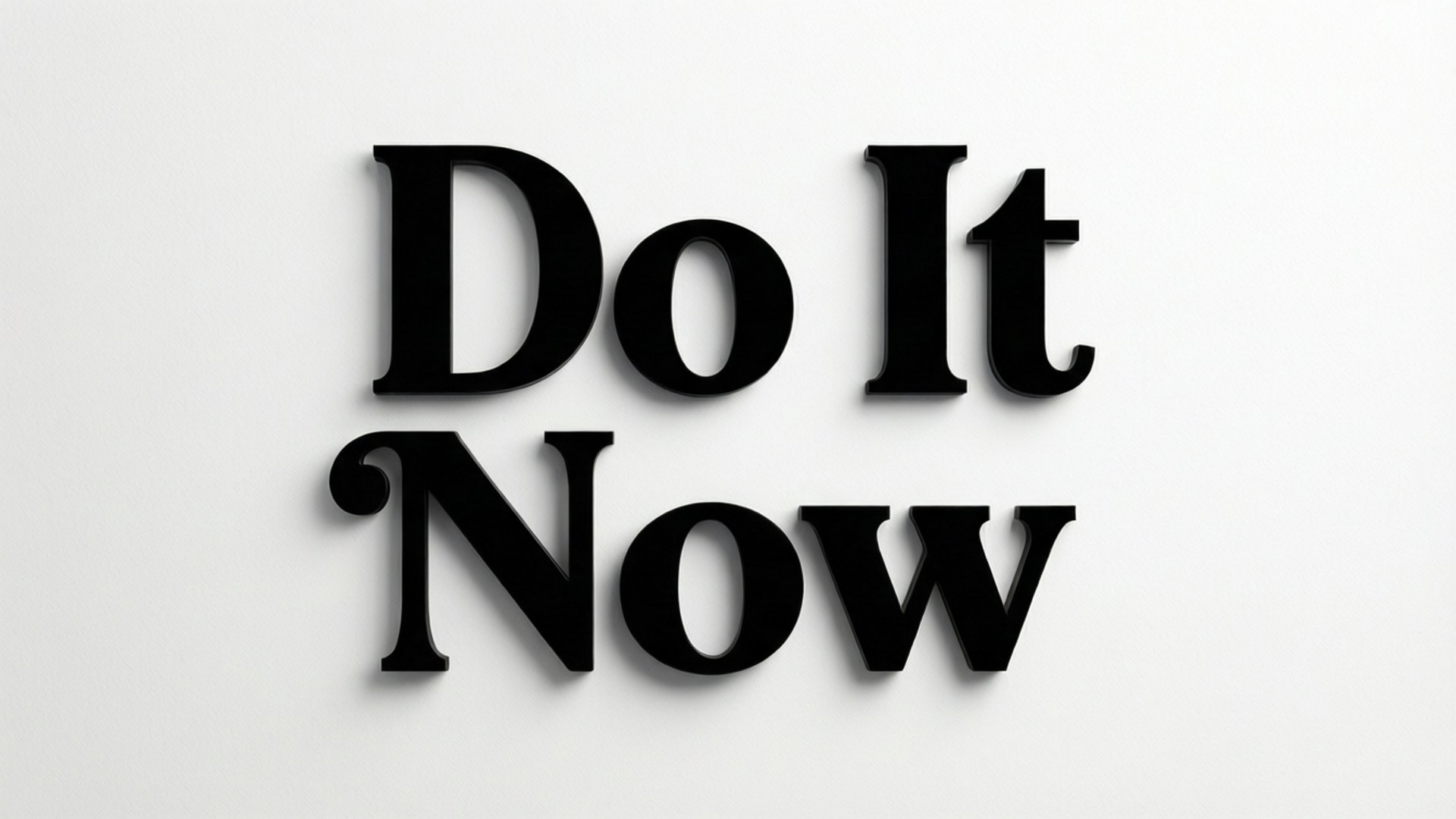 極簡主義襯線體動力 壁紙 — 粗體黑色3D字母拼出「Do It Now」，在純白牆上投下柔和陰影。