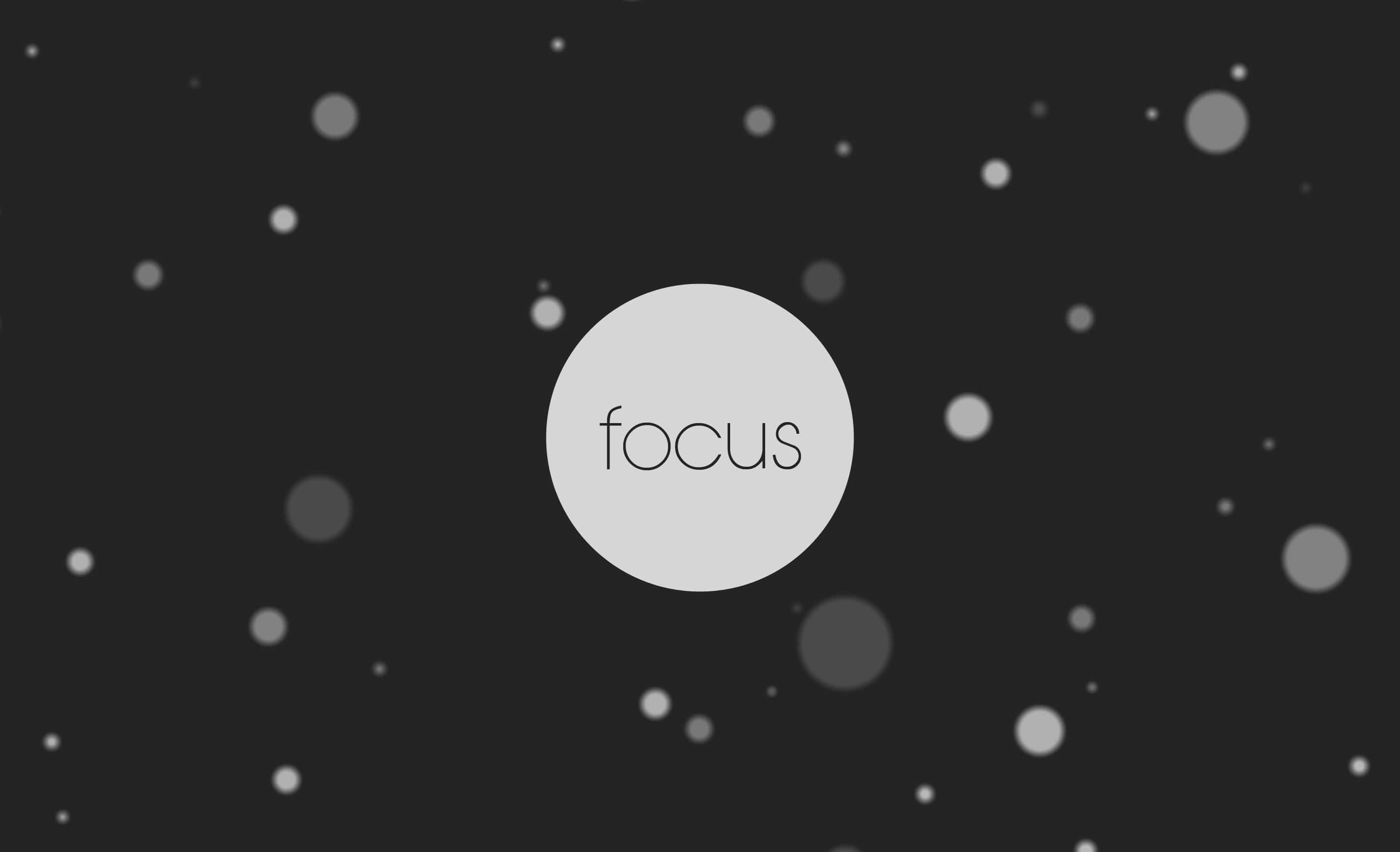Focus 桌布 壁紙 — 極簡單色設計以一個亮圓圈中的「focus」字樣為中心，背景為深色，散佈著柔和的小點。