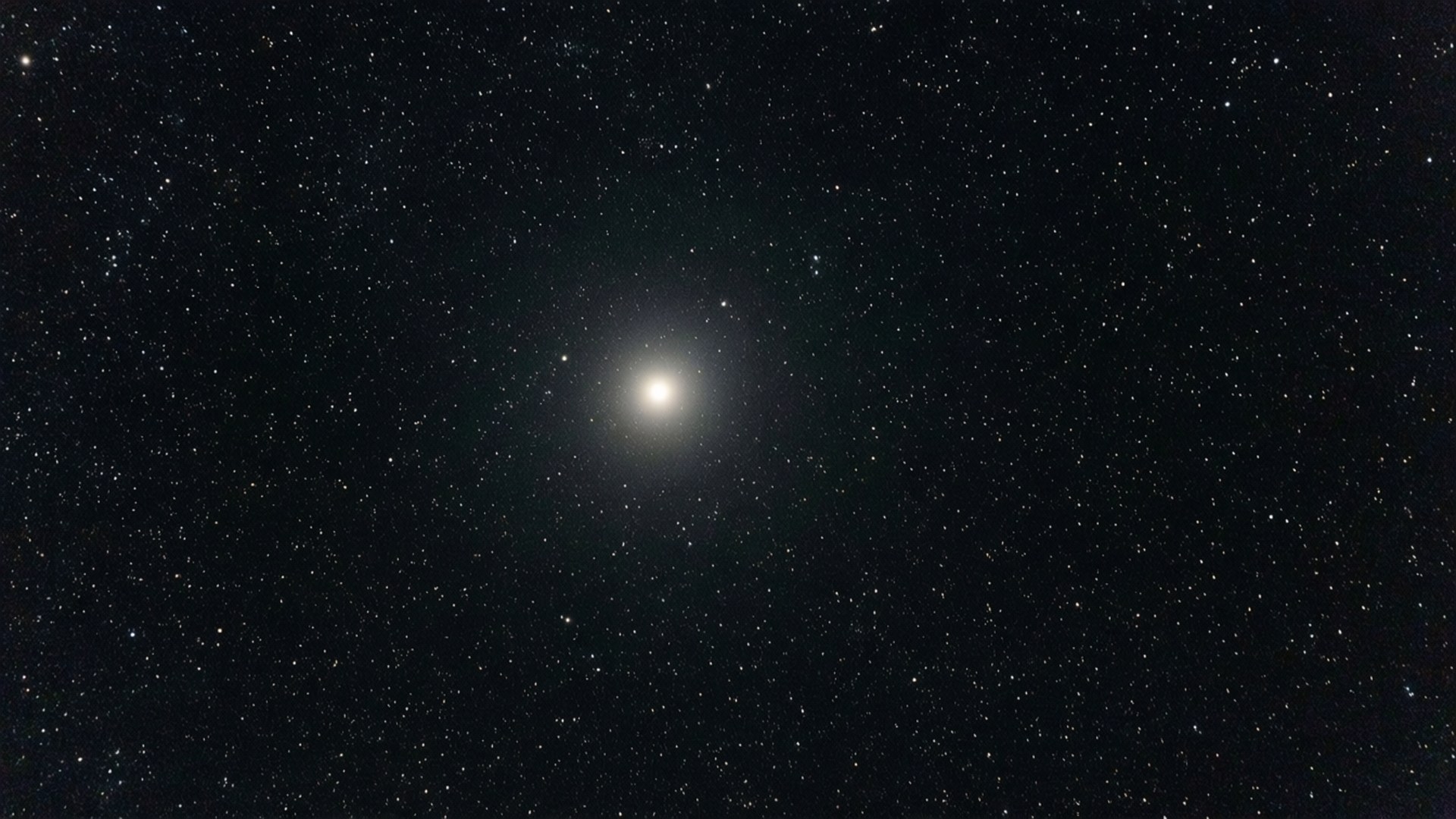 一個明亮的宇宙物體，帶有發光的光環，被深空中的星星包圍。