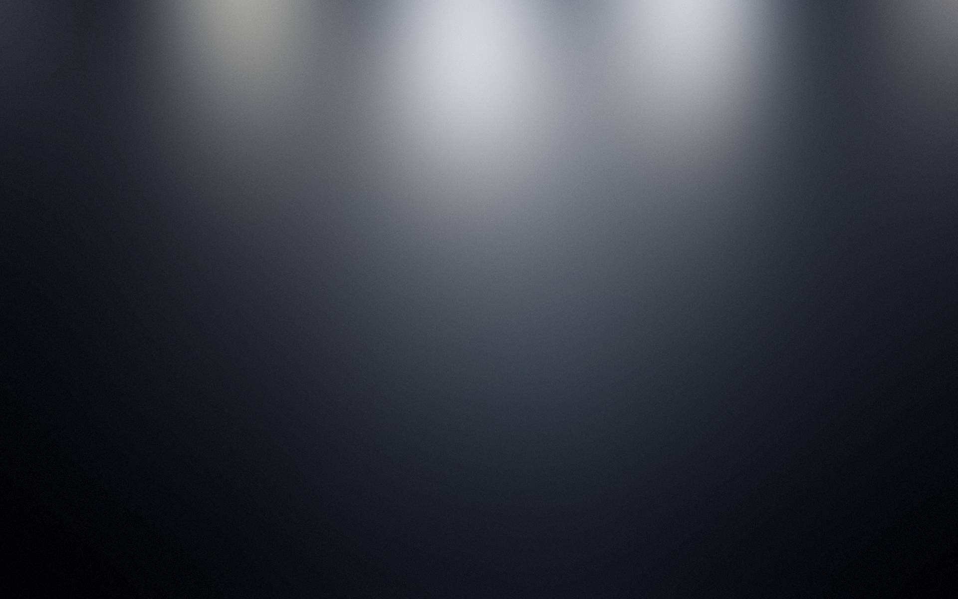 極簡深色漸層 壁紙 — 三盞明亮的聚光燈照亮黑暗的舞台，營造出從白色到黑色的戲劇性漸變效果。