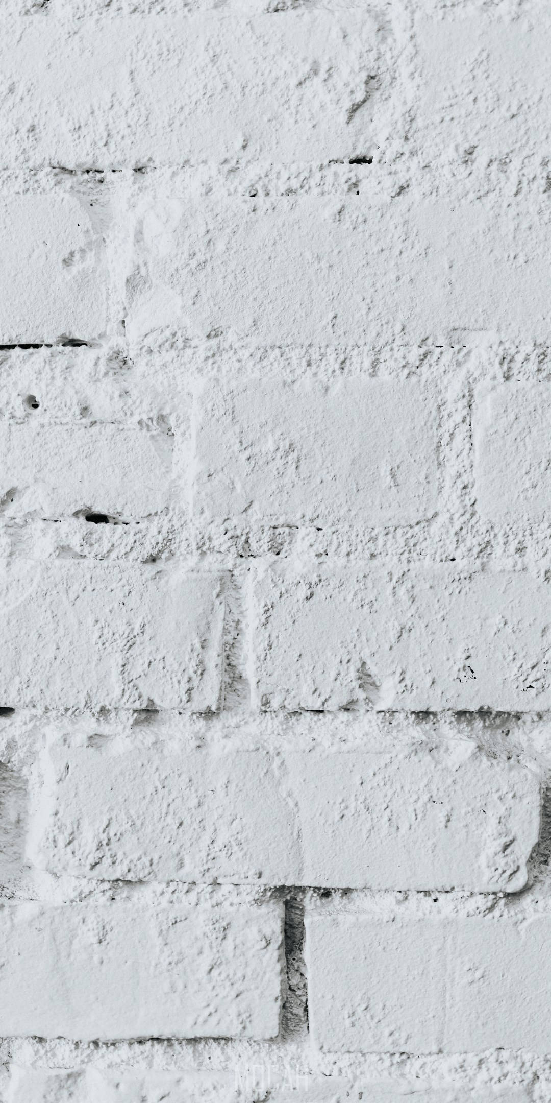 極簡現代白色磚紋質感 壁紙 — 一幅經風化的白色油漆磚牆近距離特寫，帶有紋理灰泥和微妙的灰色陰影。