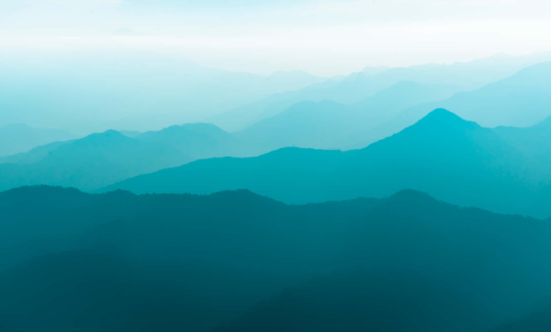 寧靜的山景，層層疊疊的山峰逐漸融入迷濛的藍色和綠色調。