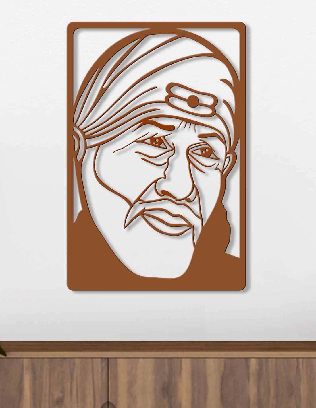 極簡風格希迪 Sai Baba 框裝畫 壁紙 — 一個棕色激光切割金屬肖像，描繪一位戴頭巾和鬍子的老人，安裝在白色牆壁上，位於木櫃上方。