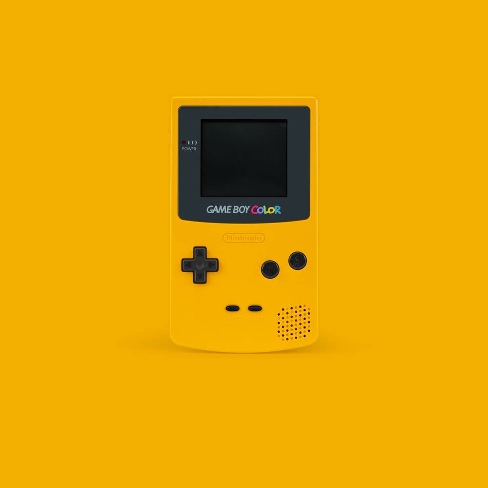 極簡黃色Game Boy Color 壁紙 — 一部亮黃色 Game Boy Color 主機置中於純黃色背景上，帶有柔和陰影。