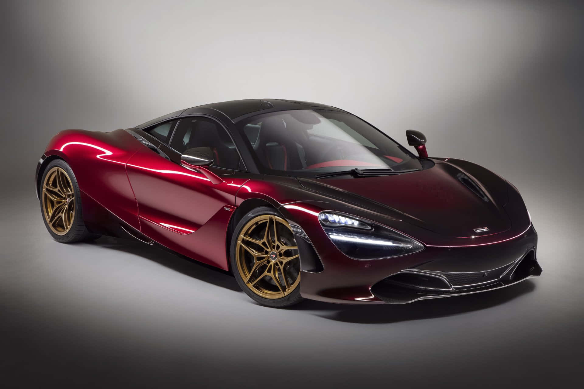 影樓燈光下的酒紅色McLaren 720S跑車配金色輪圈。