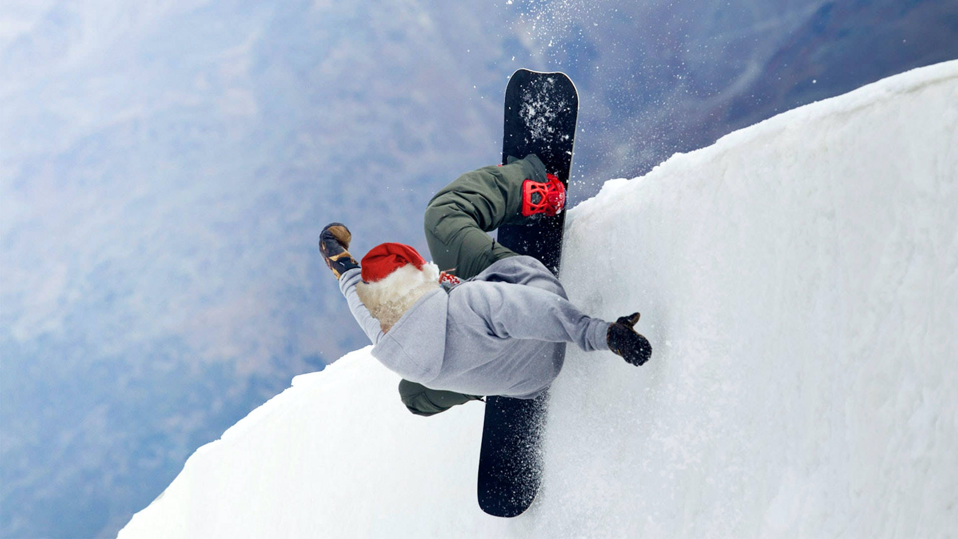 極限滑雪板 壁紙 — 戴紅帽的滑雪板運動員在白雪覆蓋的山坡上 carving，雪花向上飛濺，映襯著藍天。