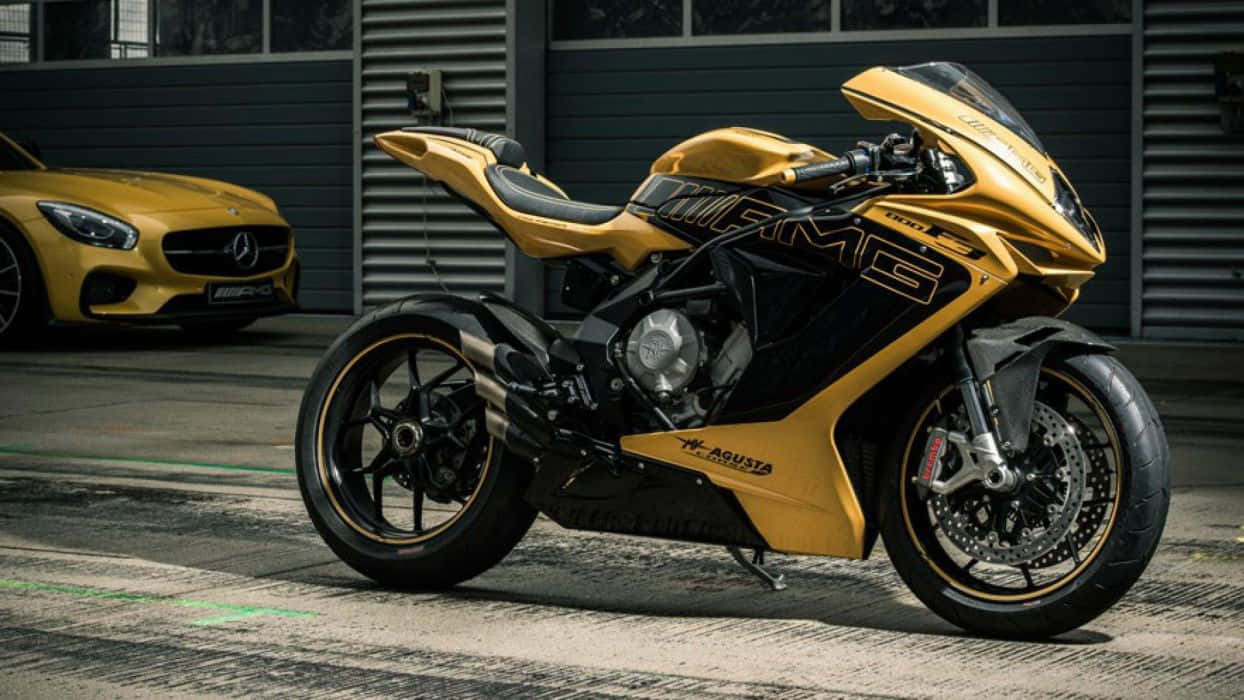 金色和黑色AGUSTA電單車停在黃色Mercedes-AMG GT旁邊的車庫中。