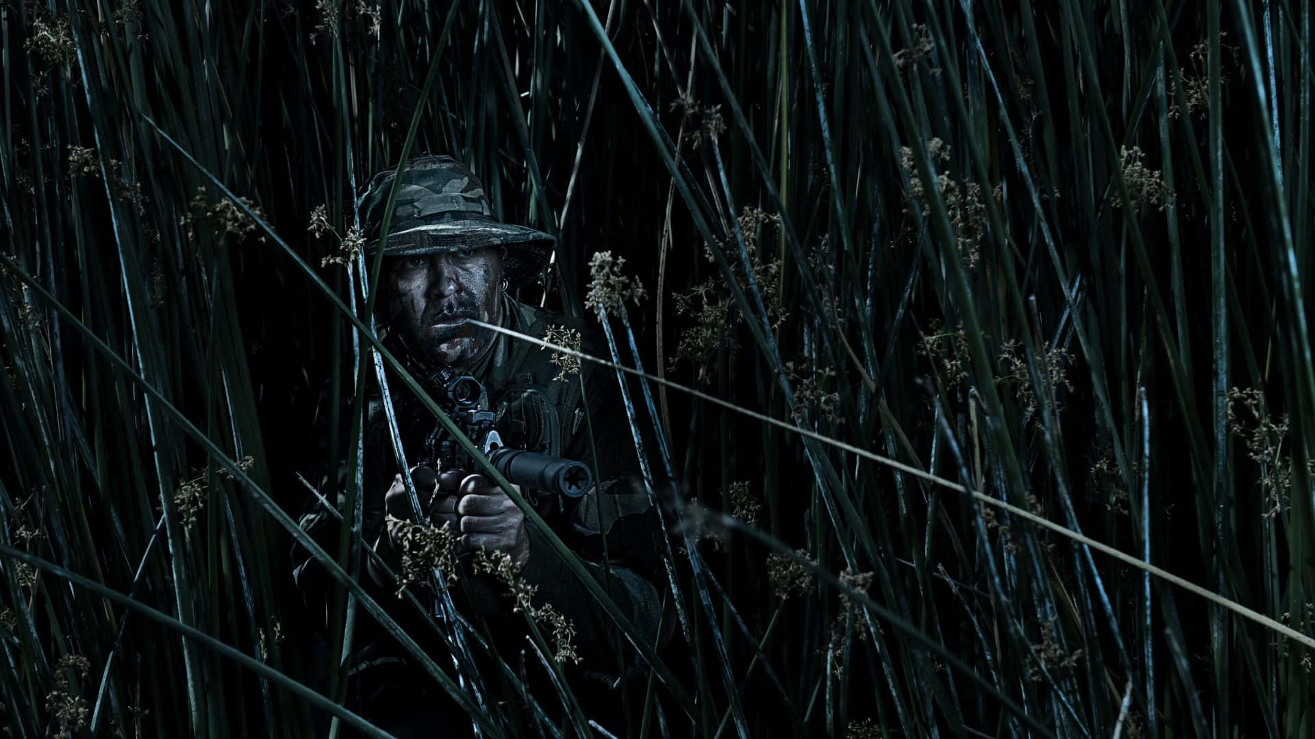 身穿迷彩裝備的士兵在夜間隱藏在高高的蘆葦叢中，手持步槍。 — 軍事動圖 壁紙