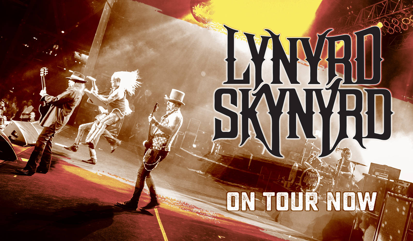 Lynyrd Skynyrd 樂隊在紅色和黃色燈光下，手持結他、戴著帽子進行現場表演。