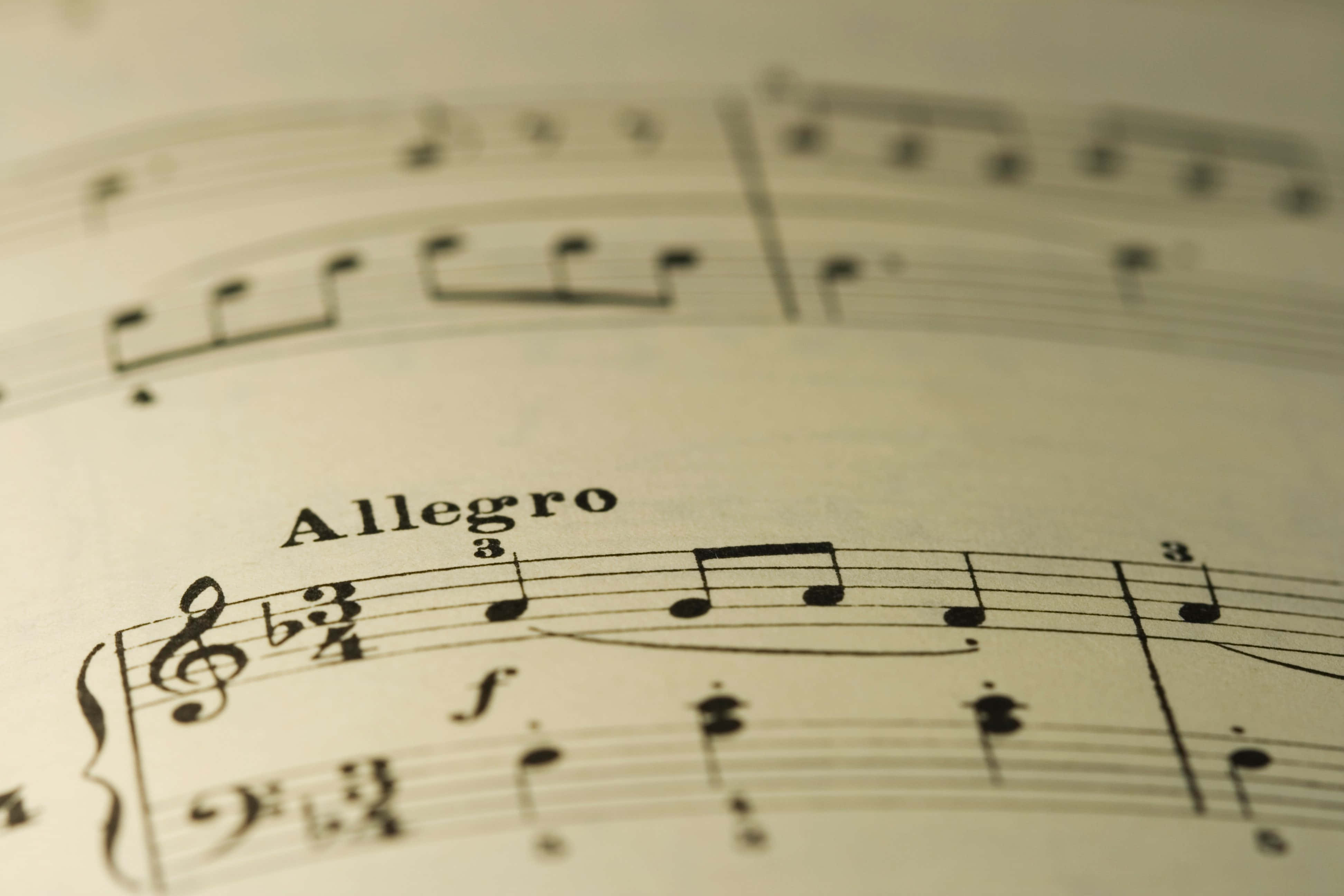 樂譜圖片 壁紙 — 復古樂譜特寫，帶有「Allegro」速度標記和音符，紙張已老化。