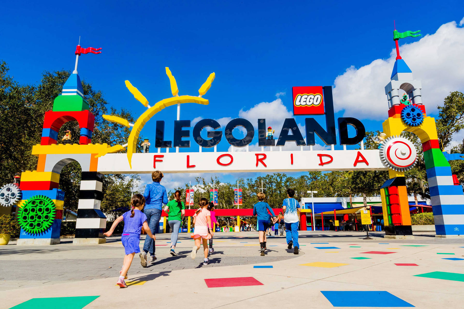 孩子們在陽光明媚的日子裡跑向 LEGO Florida 主題公園入口。