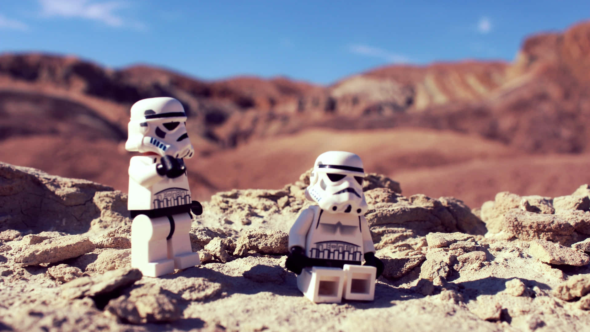 樂高克隆戰士在塔圖因背景 壁紙 — 兩個 LEGO 風暴兵企喺陽光普照嘅沙漠峽谷，紅色岩石地貌，藍天白雲。