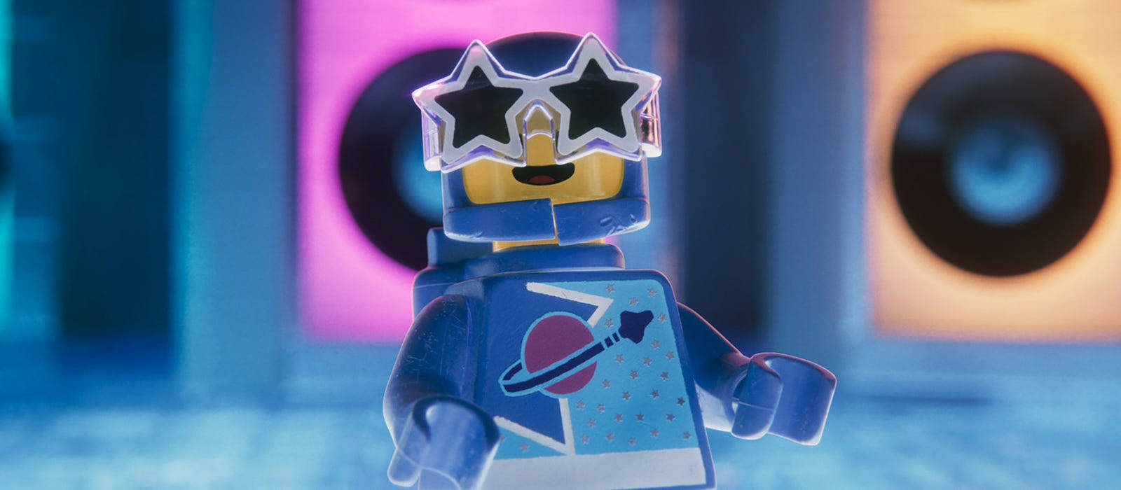 藍色LEGO人仔戴星形太陽眼鏡和太空襯衫，在霓虹燈音樂房。 — 樂高 GIF 壁紙